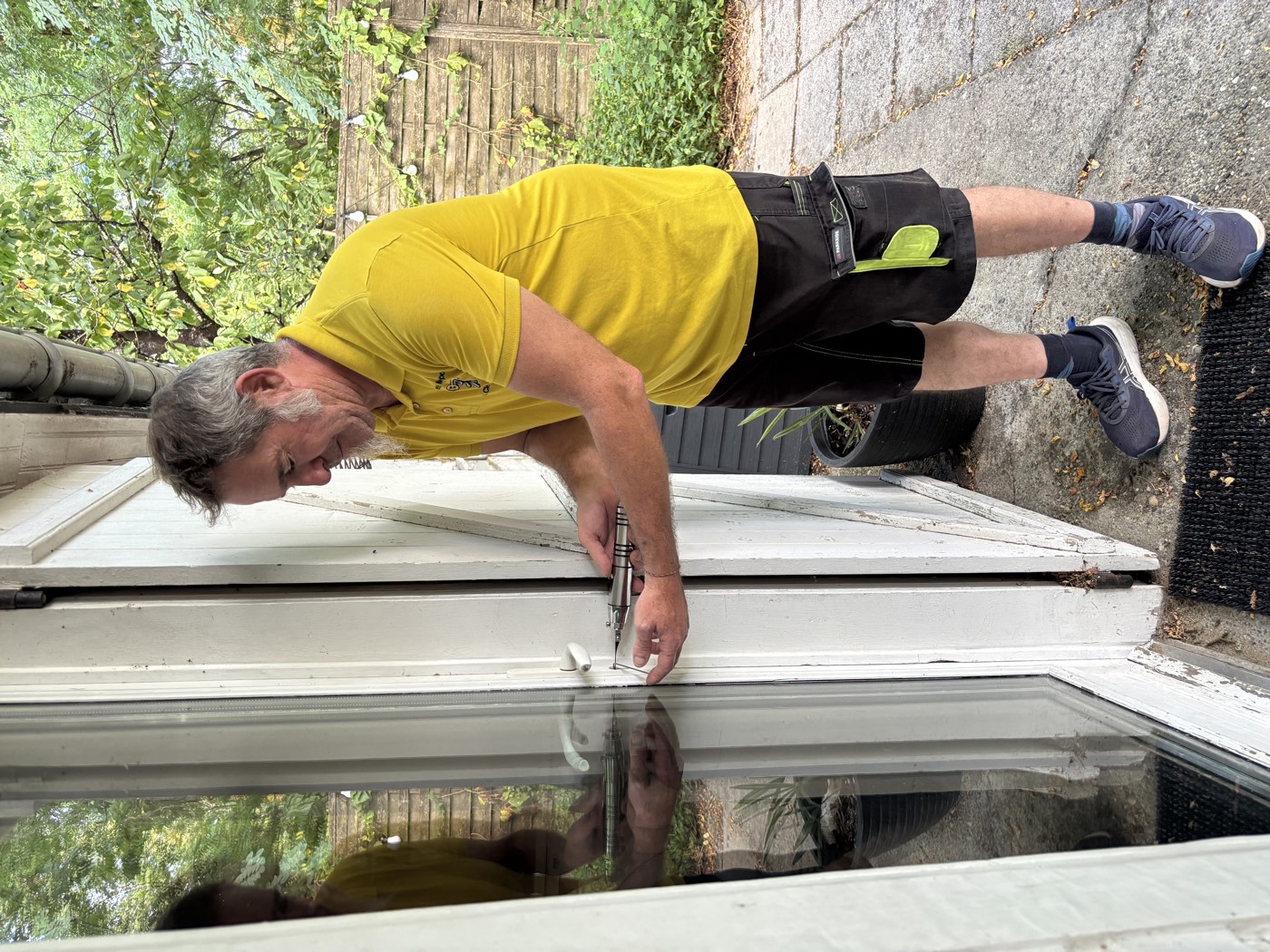 Michel intervient sur la serrure d'une porte-fenêtre donnant sur le jardin